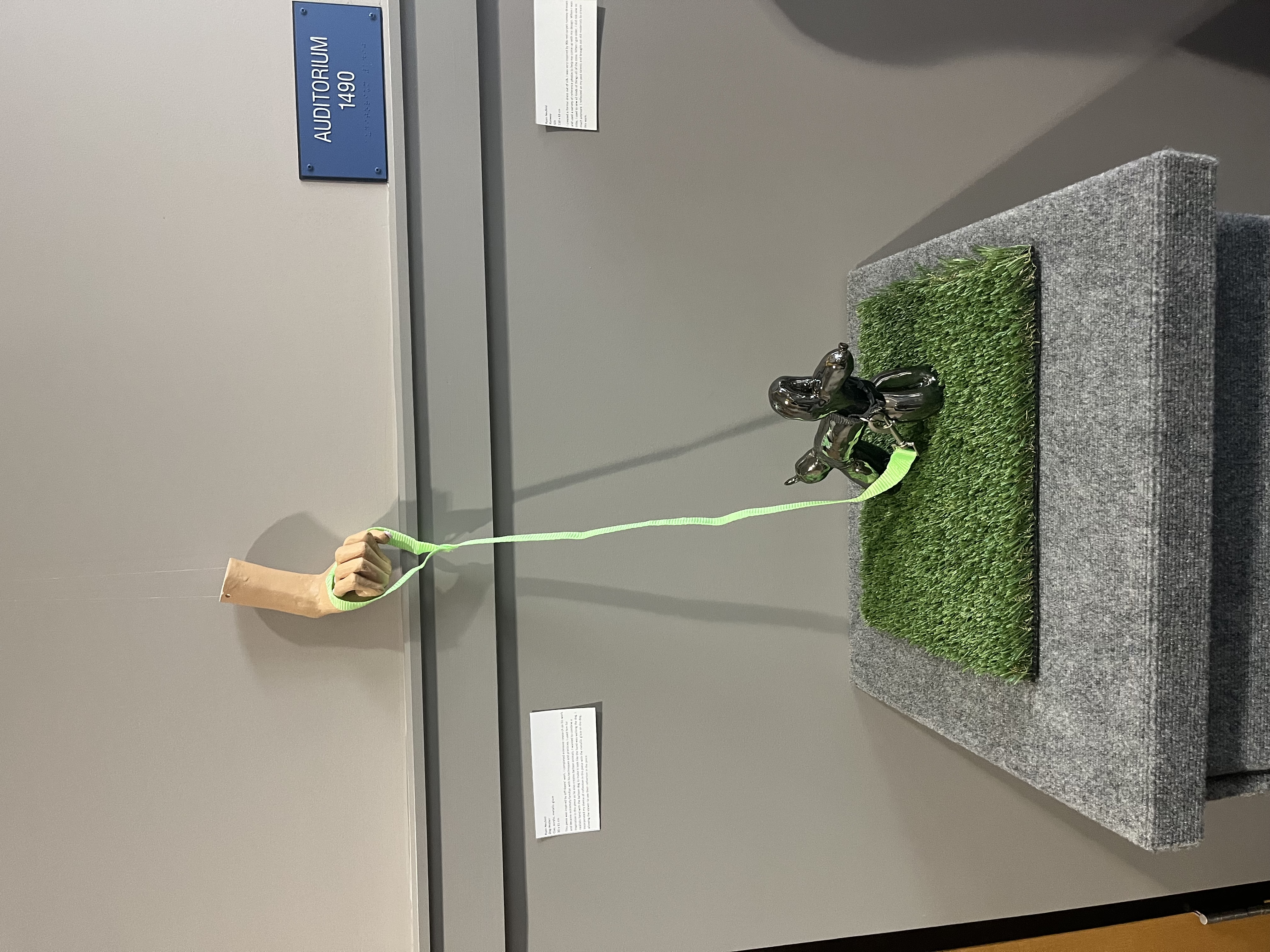 Balloon dog sculpture with hand and leash